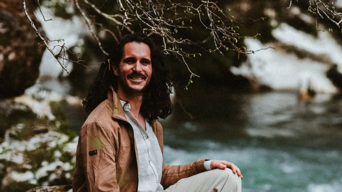 Joris assis en bord de rivière avec une veste Joris assis en bord de rivière avec une veste